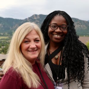 Two participants at an annual scientific society meeting pose in front of mountains in Colorado Springs, CO.