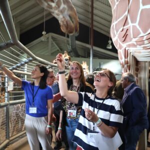 A group of participants at an annual scientific meeting enjoy the special giraffe feeding event at Cheyenne Mountain zoo as part of an annual scientific meeting.