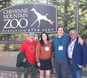 Four scientists gather at the entrance to the zoom in Colorado at the science society's annual meeting.