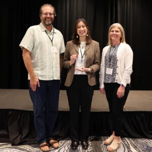 president and secretary posing with member who received an award